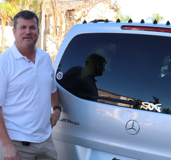 Man next to a Mercedes Metris with black AeroHance Pods Installed