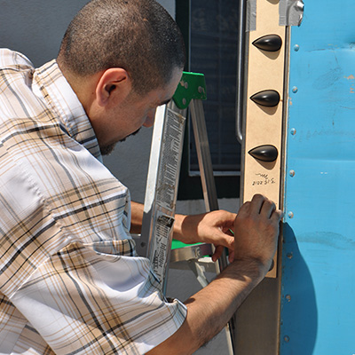 Man installing AeroHance Pods on the side of a Truck using a Template
